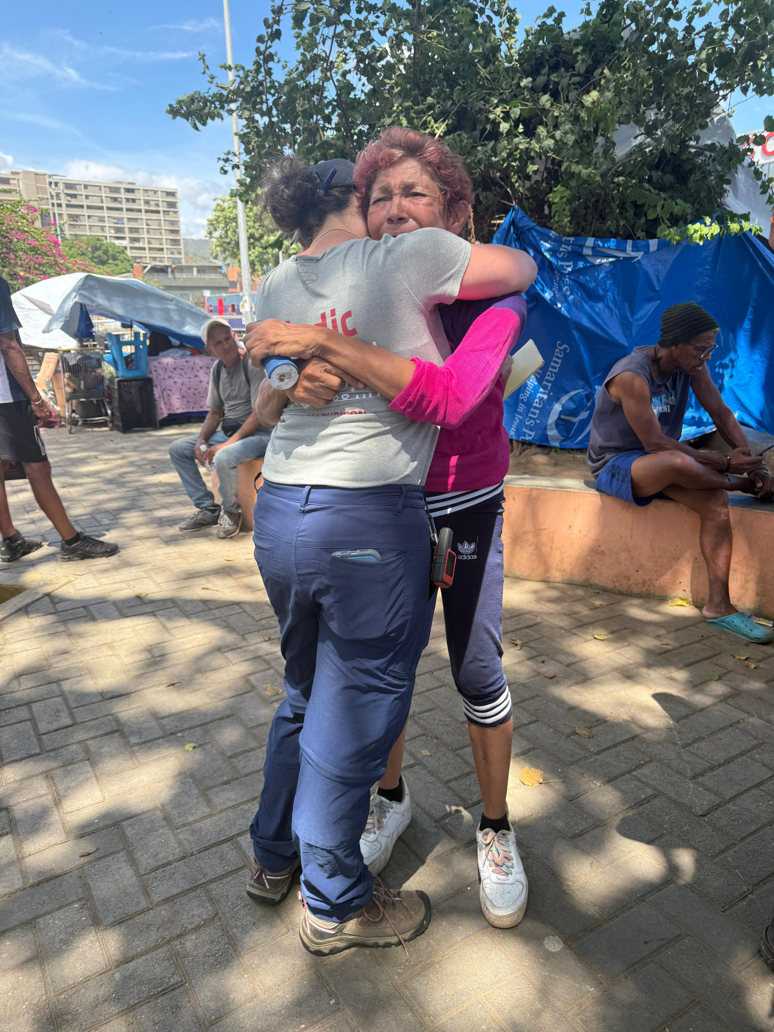 A Greyshirt volunteer hugs a local woman.