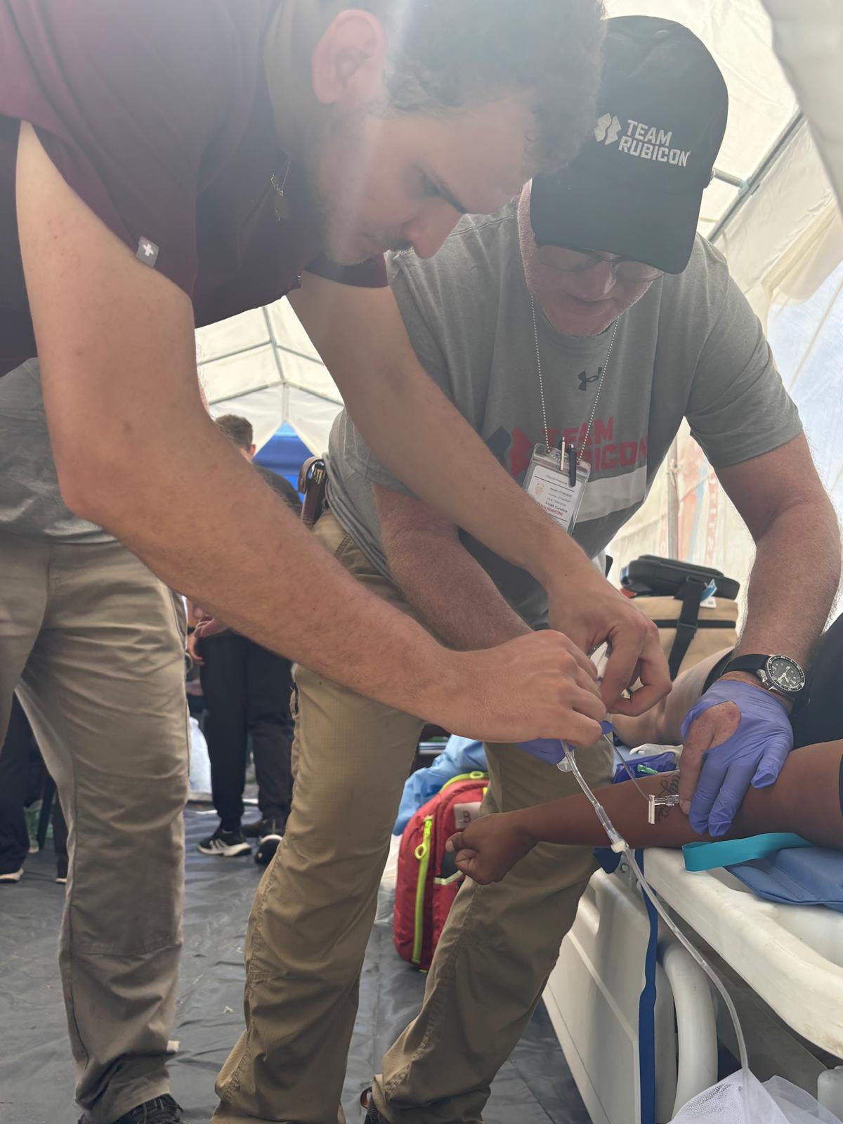 Medics tend to a patient in a medical tent.