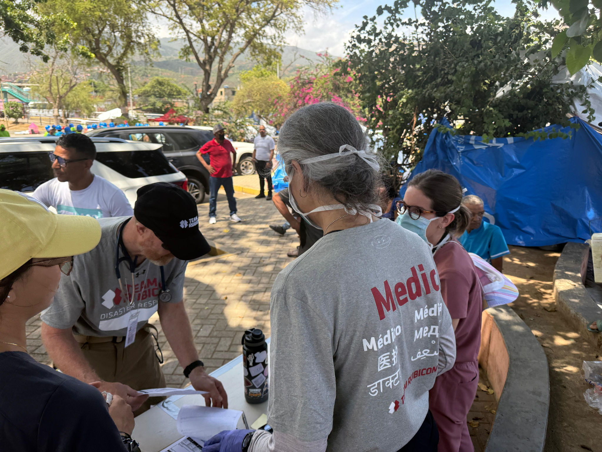 Team Rubicon medical Greyshirts stand outside checking in patients at the mobile clinic in Venezuela.