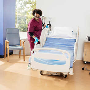 healthcare cleaning worker wiping hospital bed