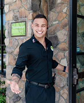 Olive Garden employee welcoming in guests at the restaurant entrance.