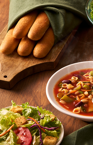Olive Garden first course featuring soup, salad, and breadsticks.