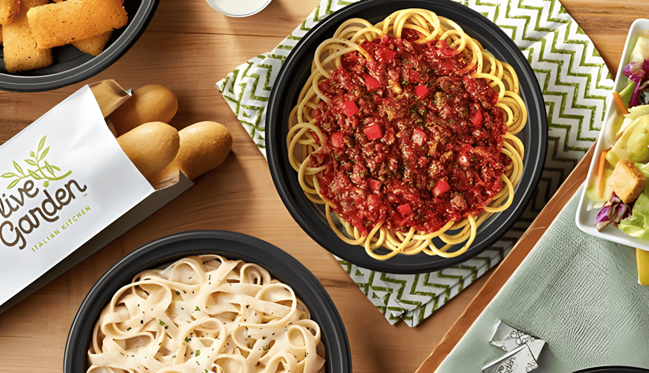 An image of breadsticks, pasta bowls and a salad