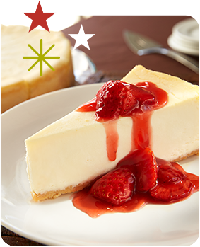 a slice of cheesecake topped with strawberries and red sauce, served on a white plate, with additional stars and starbursts in the background