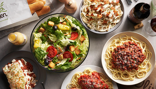 A plate of spicy pasta topped with red chili flakes and herbs, served hot and ready for delivery from Olive Garden.