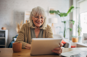 Person seated in a chair typing on a computer while smiling