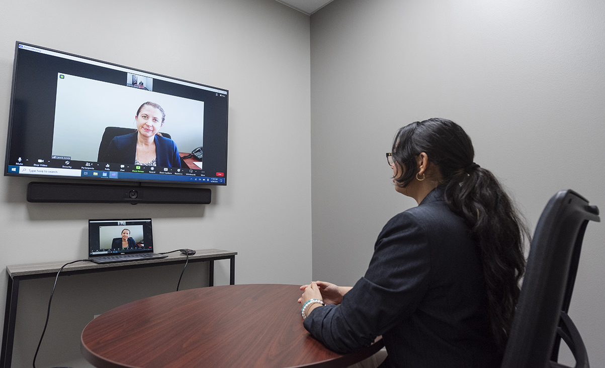 a woman sitting in a virtual meeting