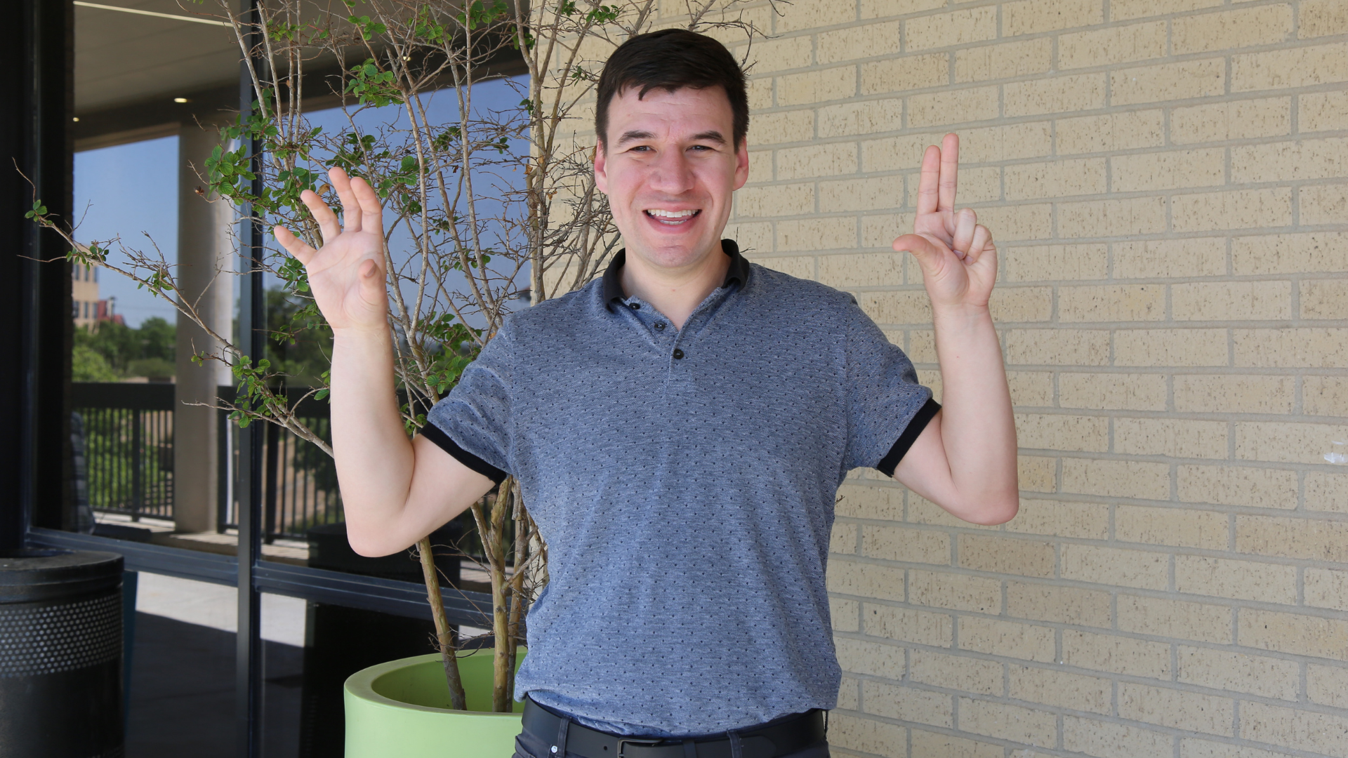 Dr. Richard Martinez posing for a photo with the Heart of Texas hand sign