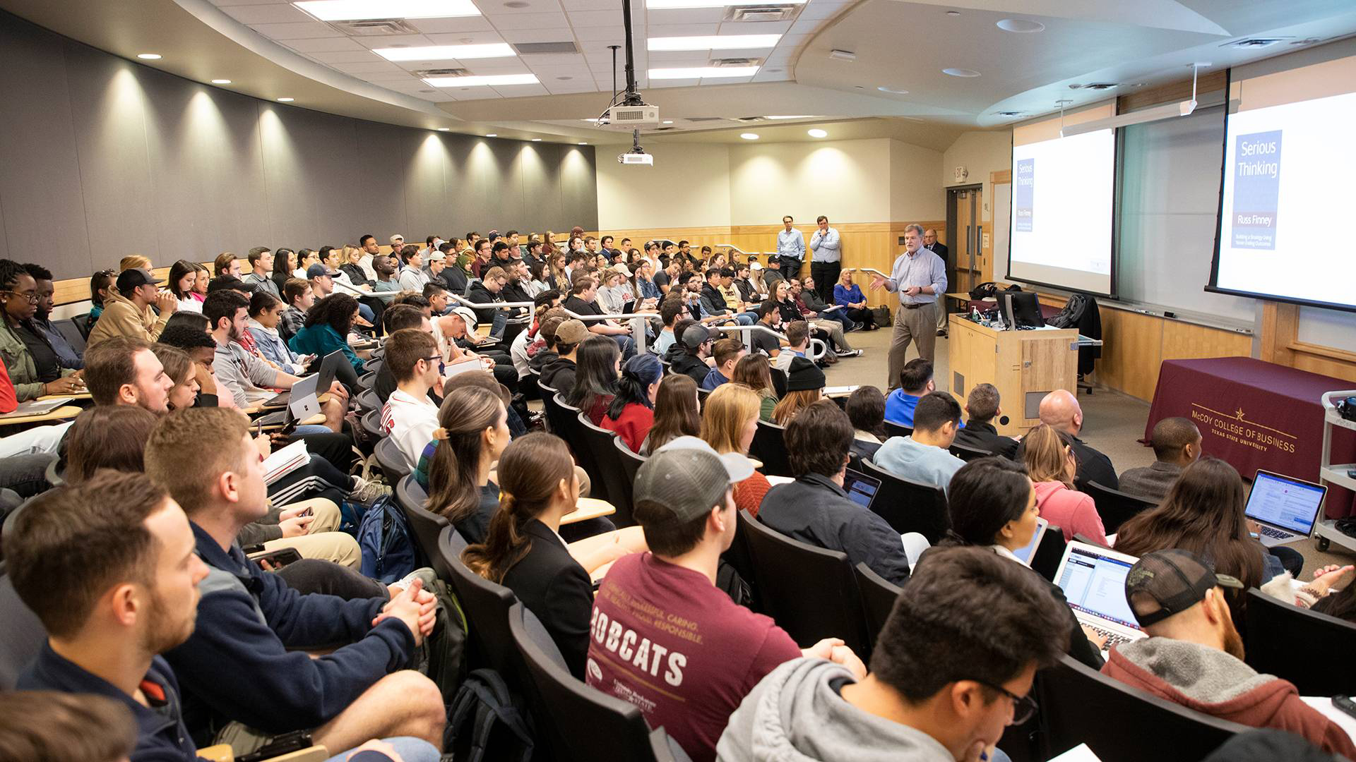 Students sitting in a large lecture hall.