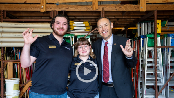 three people standing inside of a shed