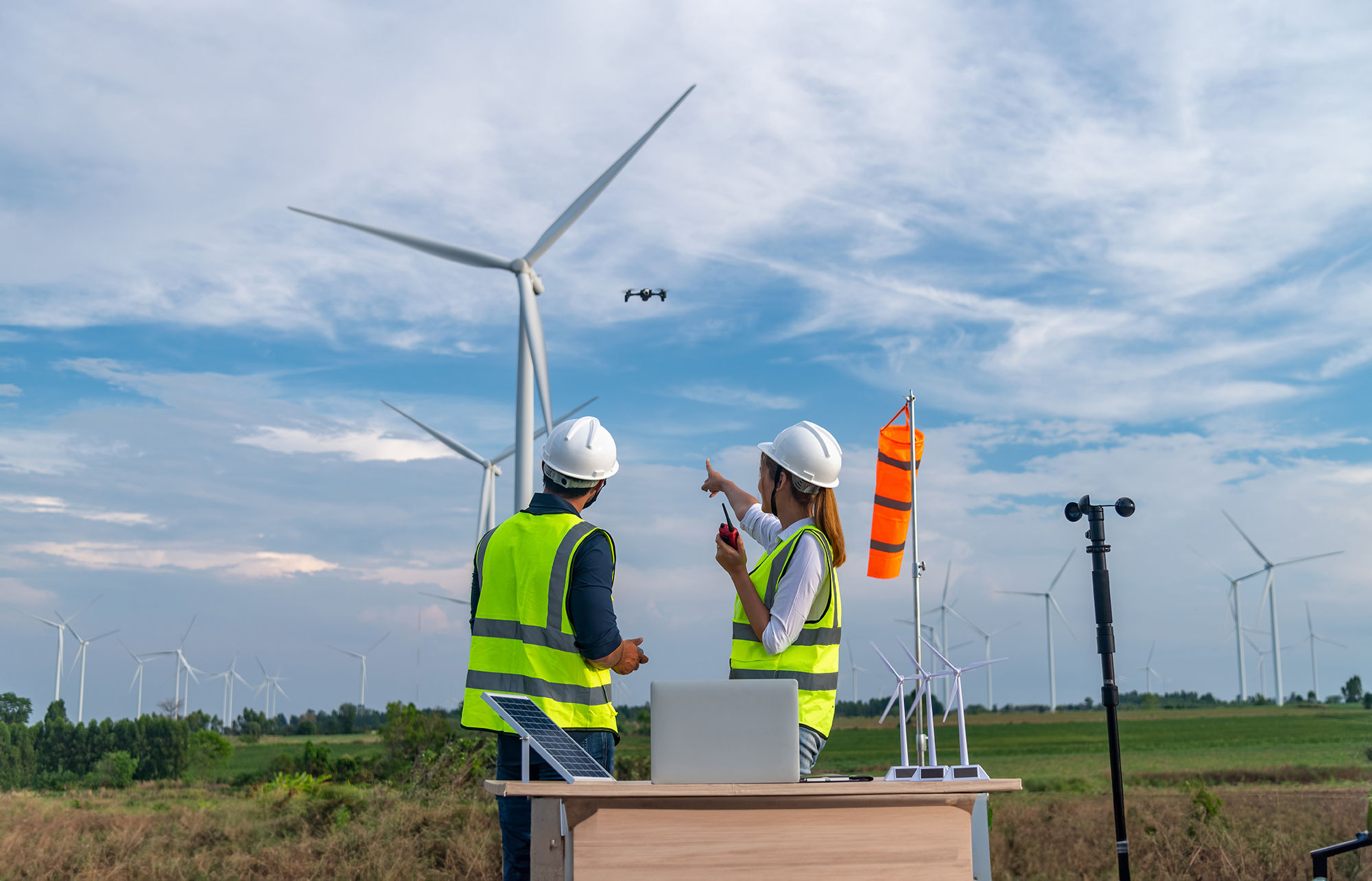 researchers in a field of windmills