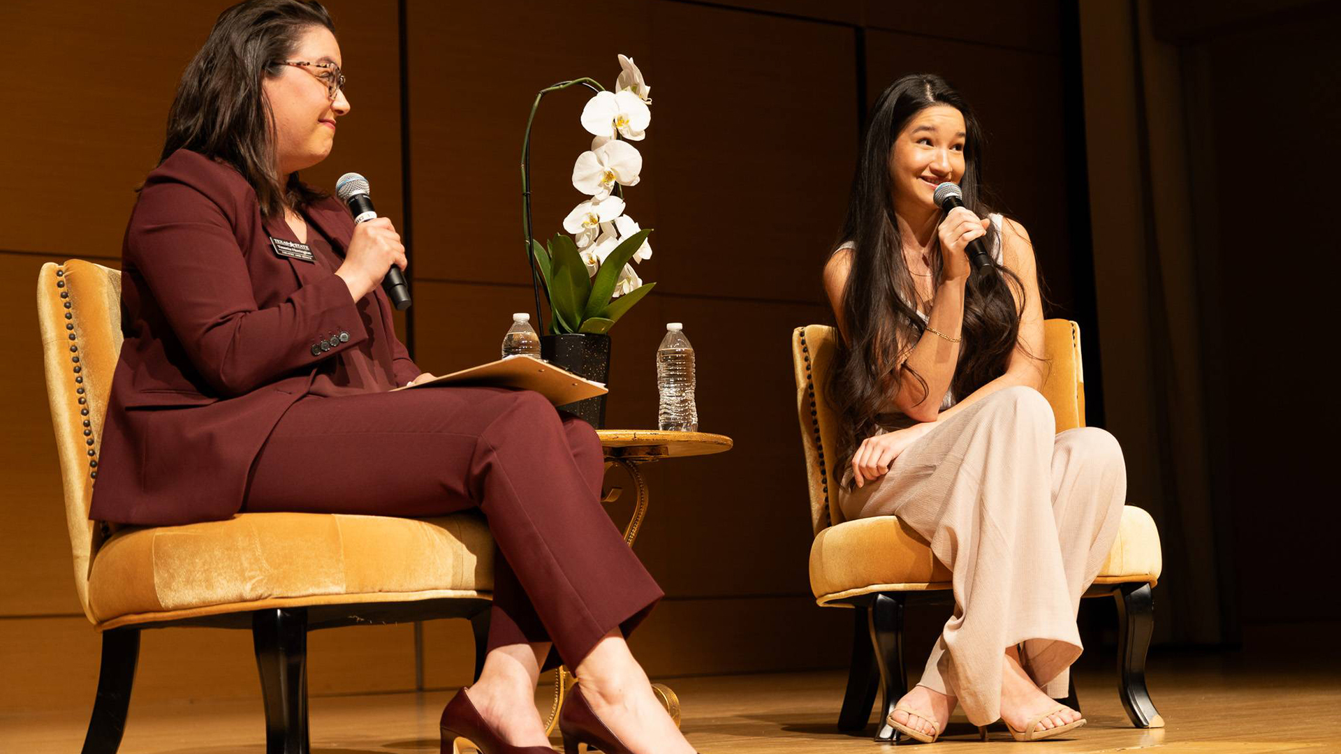 two women on stage holding microphones