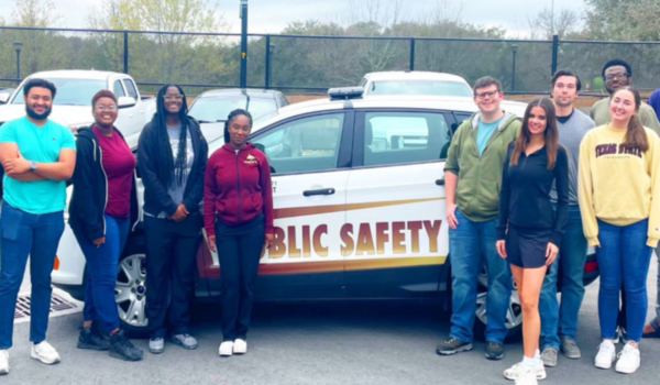 Students in front of safety escort vehicle 