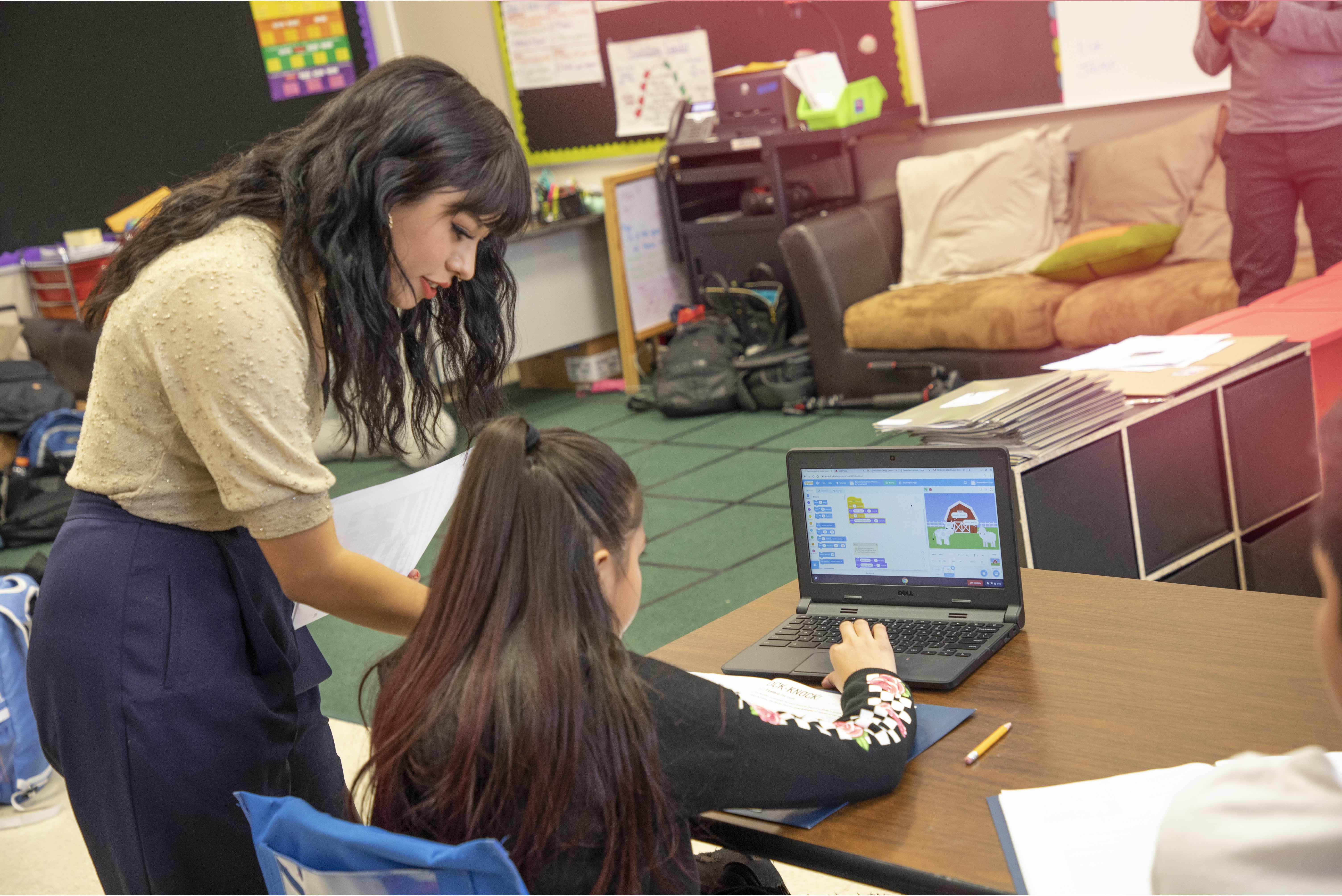 a teacher assisitng a studnet in a classroom