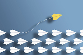 Three rows of white paper airplanes fly in tight formation, except for one yellow paper airplane that has exited the formation and gone in a different direction