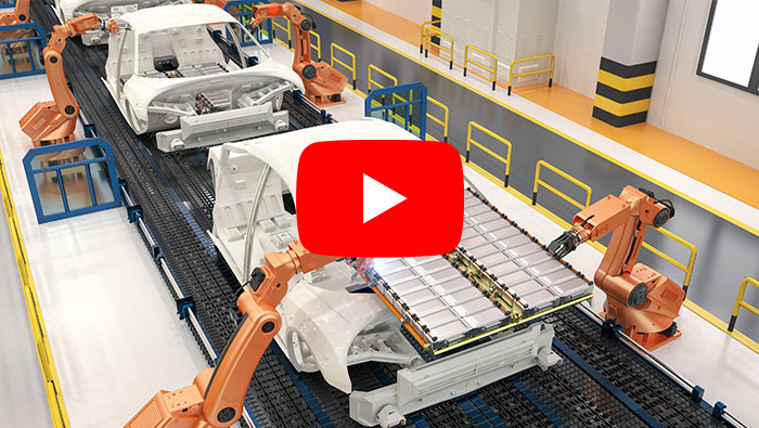 An image of electric vehicles being assembled by robotic arms with a YouTube "play" button