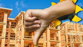 A hand showing a "thumb's down" disapproval over the top of an image of a multi-family apartment building under construction