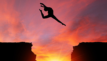 A dancer leaps gracefully across a chasm