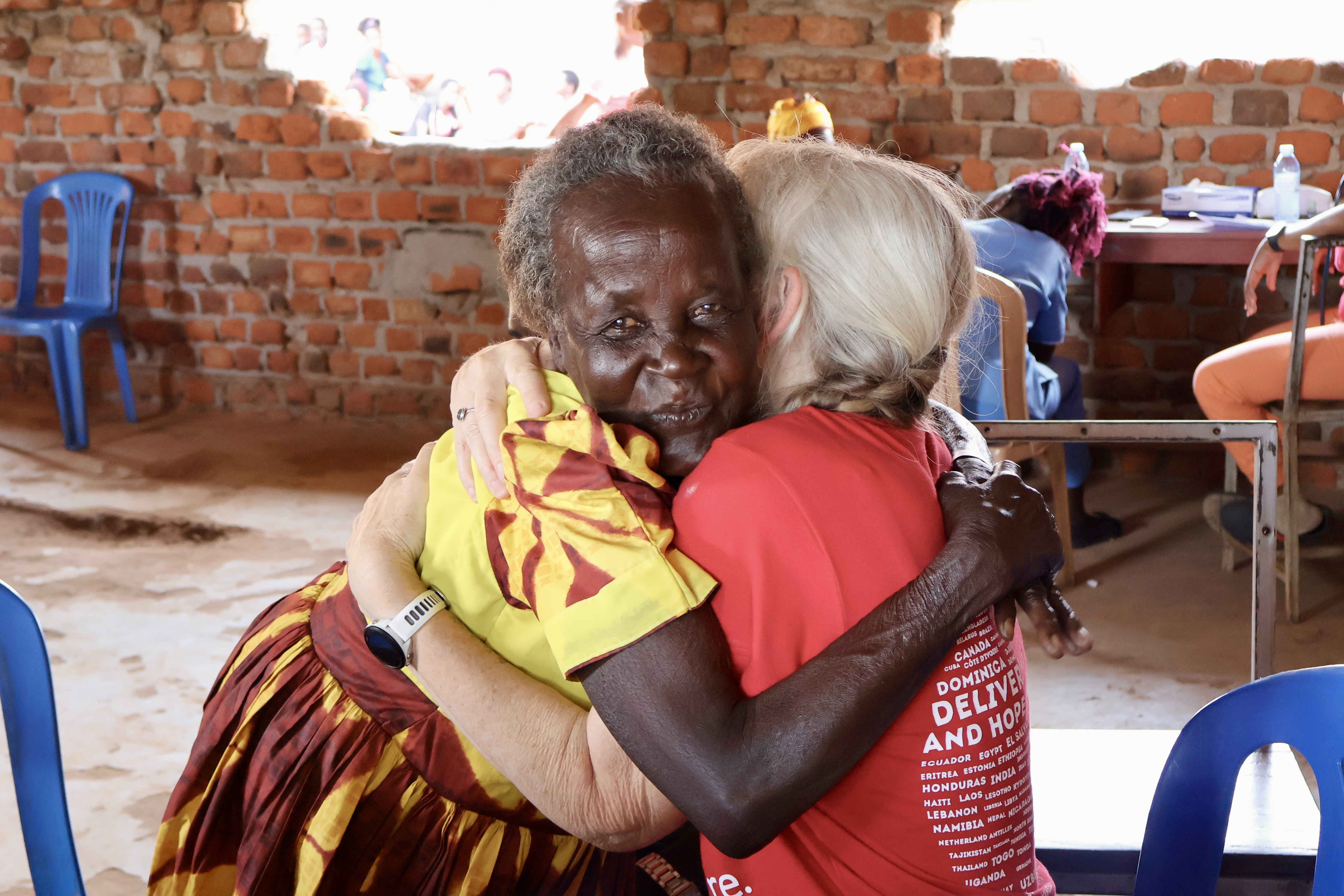 A patient in Uganda hugging a Project C.U.R.E. volunteer during a C.U.R.E. Clinic. 
