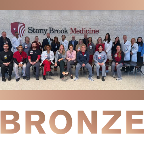 Photo of the bronze Centers of Excellence winners in front of a Stony Brook Medicine sign