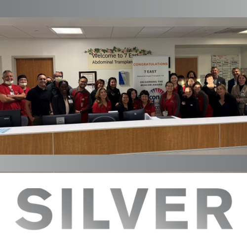 Photo of the silver Centers of Excellence winners behind a hospital desk