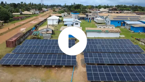 Drone shot above solar panels with a play button over it.