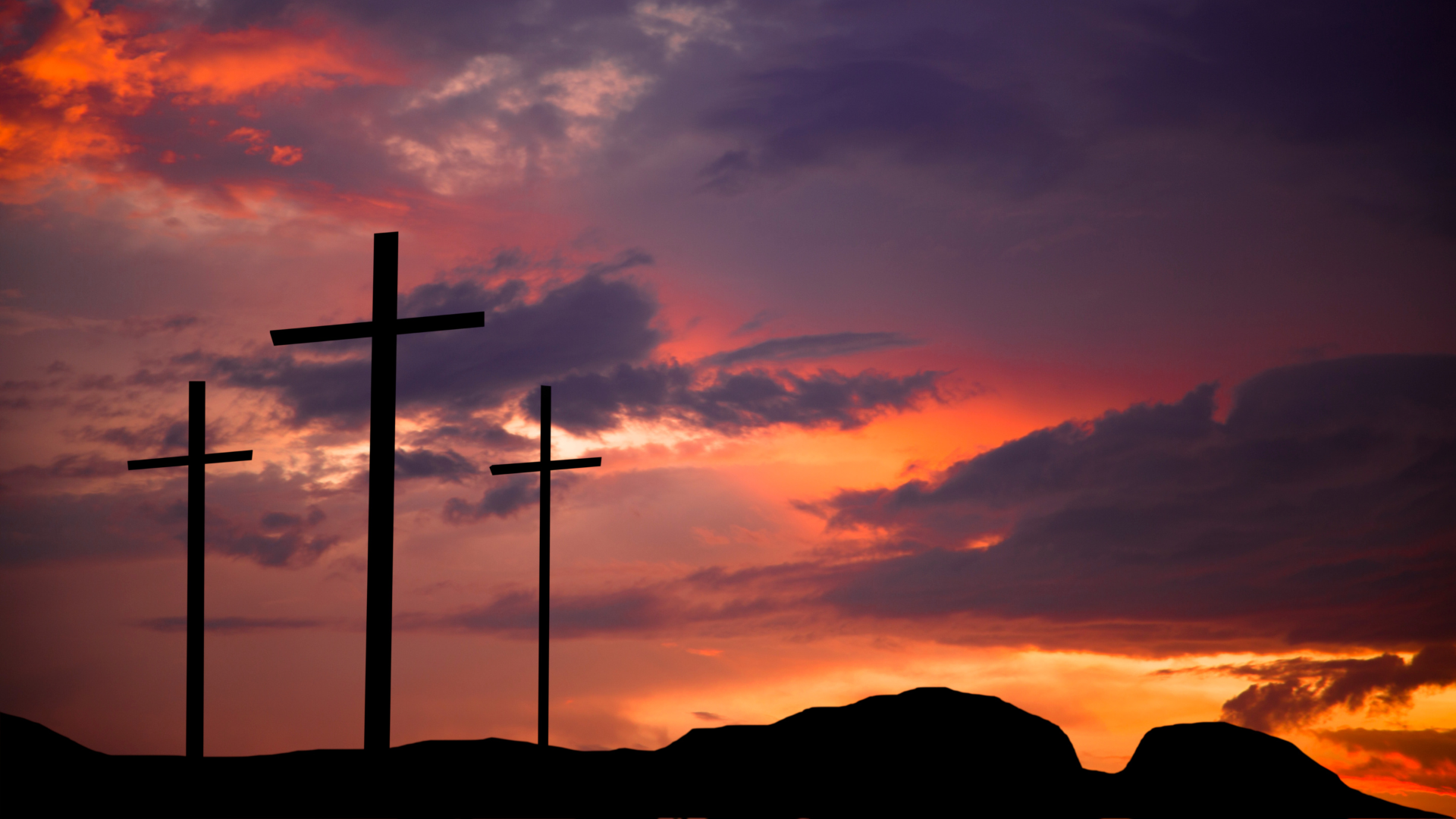Three crosses on a hill with a sunset in the background - Golgotha