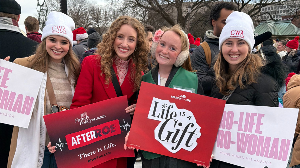 Four girls holding signs at the March for Life Rally