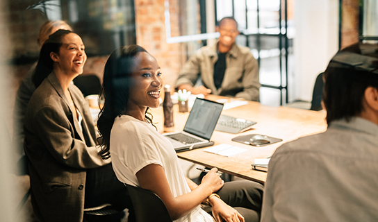 People gather in a meeting room to discuss work in an office
